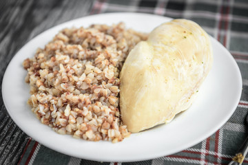 Boiled chicken breast and buckwheat on grey wooden background. Healthy lunch or dinner.