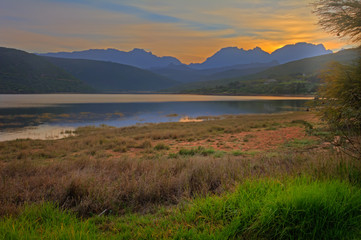 Dawn over lake with blue mountains