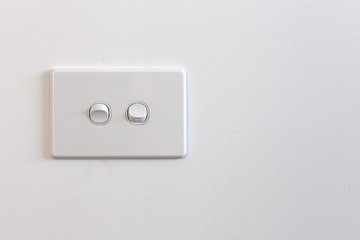 Modern double light switch on white wall with copy space