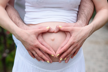 A pregnant woman and a man holding his stomach. The concept of waiting for the birth of a child.