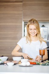 Young attractive female arranging all foodstuff from ref on kitchen table, creating healthy...