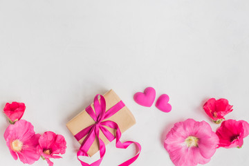 Flat lay desk with pink flowers and gift