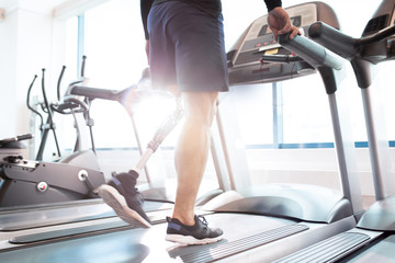 Close-up of disabled man walking on treadmill