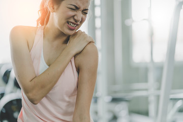 woman get accident between workout in gym shoulder pain and hurt with wrong posture  exercise