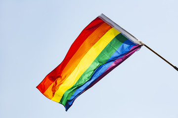 Gay flag on blue sky background. Big rainbow flag.