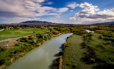 Fototapeta na wymiar Aerial view of a river and golf course with mountains in the distance