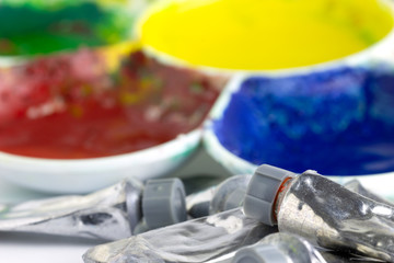 Color tubes and palettes placed on white background. Suitable for background, articles about artistic.