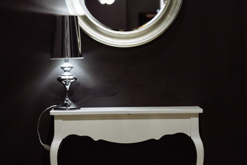 white mirror with white desk in front of black wall