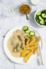 Beef Stroganoff traditional Russian dish of beef in sauce, served with fried potatoes, canned cucumbers, vodka.