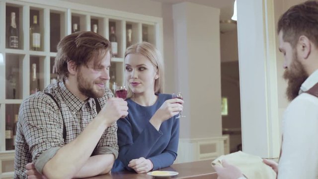 Attractive elegant young couple drinking a cocktail at the restaurant. Handsome loving couple flirting in a cafe. Love and romance. Lifestyle concept