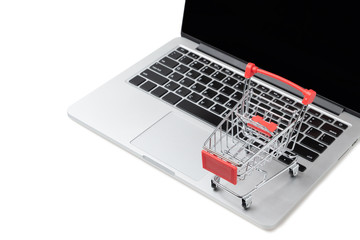 Shopping cart on a laptop keyboard isolated on white background, E-commerce, Shopping cart on laptop, Conceptual image, Ideas about online shopping