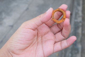 Hand Holding A Piece of Rustic Hex Nut