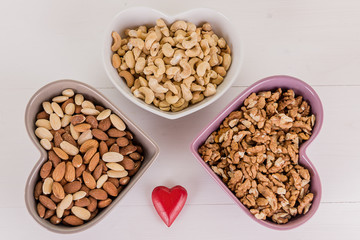 healthy brain heart food nuts in heart shape dish on white wood background 