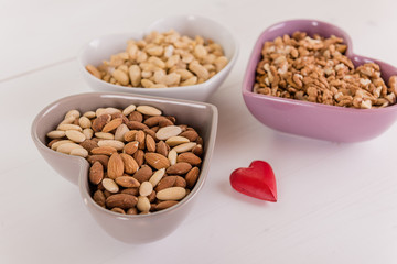 healthy brain heart food nuts in heart shape dish on white wood background 