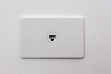 Network connection wall outlet on white wall with copy space