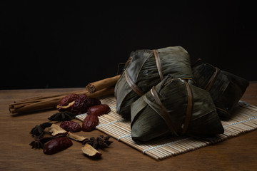 Zongzi or Traditional Chinese Rice Dumplings in a Bamboo leaf on a Wooden Table for Dragon Boat Festival or Dumpling Festival
