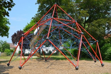 Großes Kletternetz mit Rutsche auf dem Spielplatz eines Wohngebietes