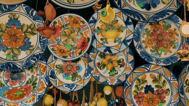 tracking shot typical hand-painted majolica plates hung in a market in Valencia, Spain