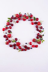 Summer concept. Flat lay, top view, copy space.  Frame made of fresh berries. Strawberry, blueberry and sweet cherry