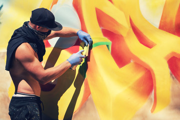 street artist painting colorful graffiti on the wall