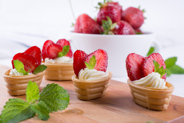 Mini tartlets on the plate . Homemade dessert with delicious cream cheese and fresh berries