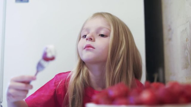 Girl child eating strawberries