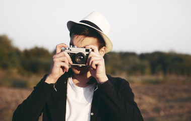 Young man taking photos with retro camera