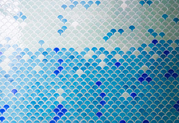 Tiles wall. The turquoise blue tiles wall with under the sea inspiration of fish scale pattern. Window light.