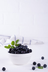 Fresh raw organic farm blueberry in white bowl  on white background, copy space