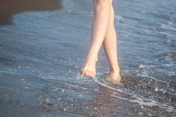 Closeup of a female's bare feet walking at a beach. Concept of the travel, vacation