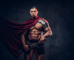 Fototapeta na wymiar Brutal ancient Greece warrior with a muscular body in battle uniforms