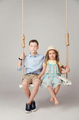 boy and girl sitting on a swing