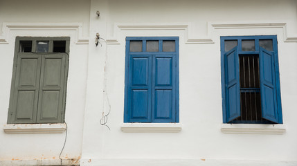 Three windows on a white ancient building