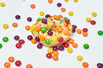 Appetizing golden donut sprinkled with colorful chocolate pellets.