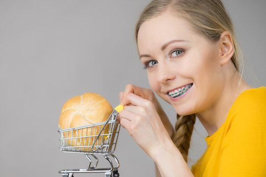 Woman holding shopping cart with bread