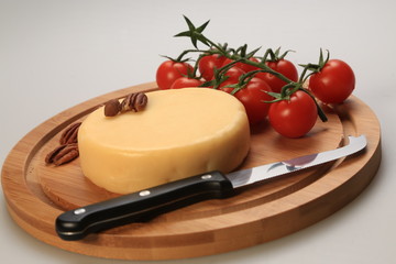 Small cheese wheel next to cherry tomatoes