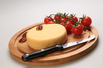 Small cheese wheel next to cherry tomatoes