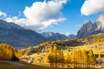 Gorgeous sunny view of Dolomite Alps with yellow larch trees. Colorful autumn panorama view landscape. Italy