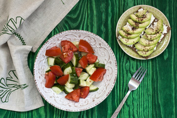A healthy salad of fresh tomatoes and vegetables and a homemade soft cheese sandwich, avocados and seasoning on toast of hard wheat. A healthy breakfast.