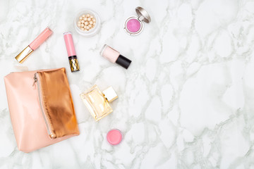 Female decorative cosmetics and cosmetic bag on a marble background. Copy space