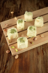 Turkish dessert. Cotton candy with pistachio on wooden boards surrounded by nuts