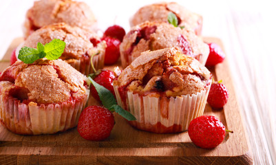 Strawberry cakes on wooden cutting board