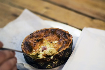 Person eating quiche lorraine