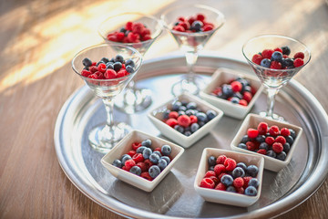 Berries of blueberries, raspberries in a beautiful vase on the table