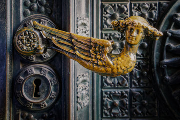 The doors of the cathedral in Cologne are made out of bronze. A Cherubim is the door handle.