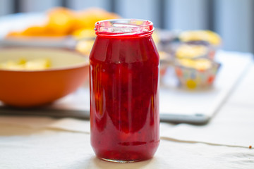 glass jar with red sweet jam on the table
