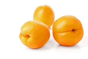 ripe juicy yellow apricots on a white table