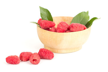 ripe juicy raspberries with leaves in a plate on white table