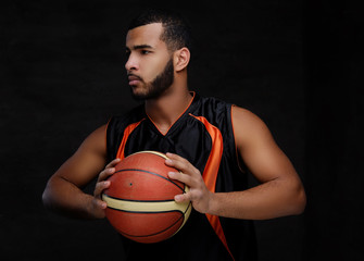 Portrait of an Afro-American sportsman. Basketball player in sportswear with a ball