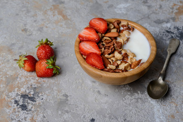 Healthy breakfast  with muesli,  berries and nuts in bowl on grey background. Healthy food concept.